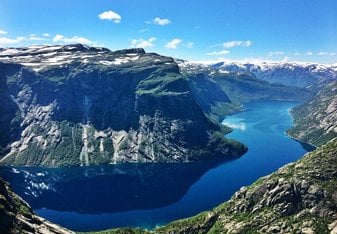 A scenic landscape of a deep blue winding river cutting through cliffs.