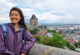 A girl posing with a city in the background.