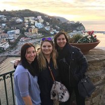 Three girls standing in front of the Amalfi Coast at sunset. 