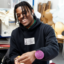 Student laughing while working on a garment.