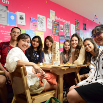 Group of students at a Summer Social, smiling and sitting around a table